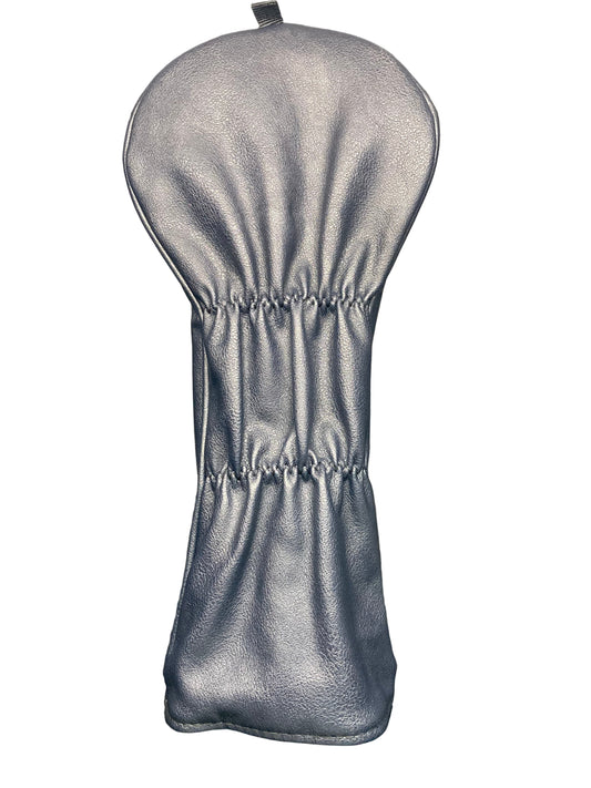 Silver golf club head cover on a reflective surface